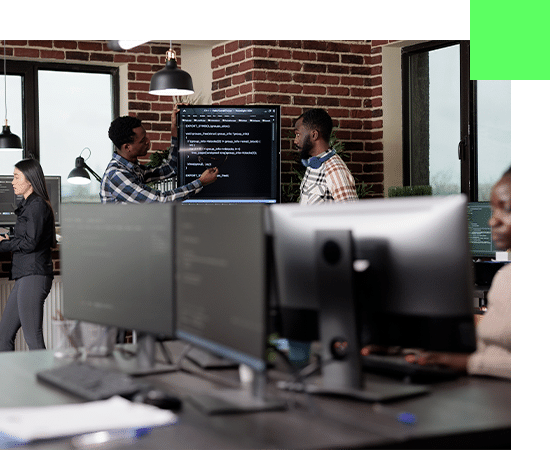 Photo de deux collaborateurs d'une ESN française et africaine entrain d'échanger sur un projet IT autour d'un écran tactile remplit de code.